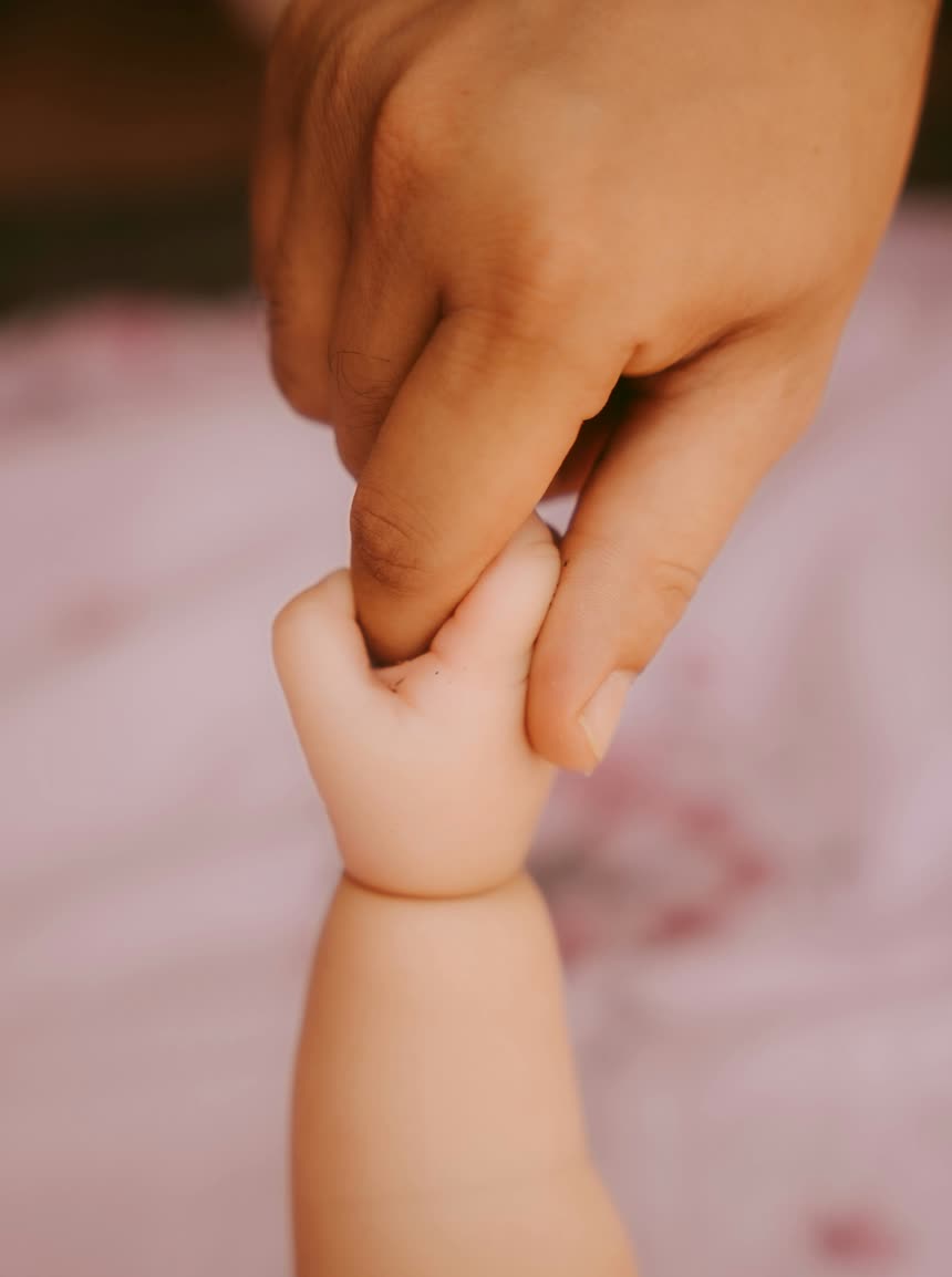 Newborn baby hand gripping parent finger - the miracle of life